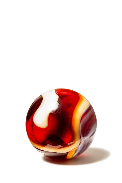 A red, white, and orange swirl glass marble with shadow on white.