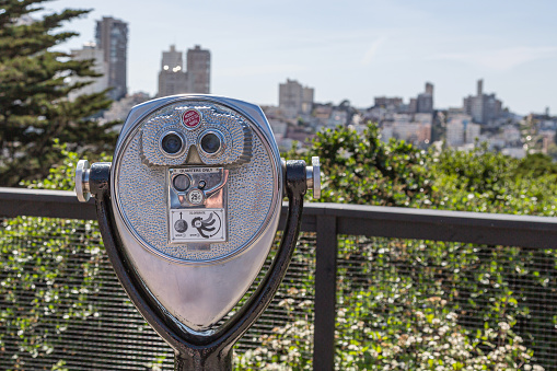 Coin operated binoculars with view of San Francisco. Closeup binocular on background viewpoint observe vision. Closeup of tourist coin operated binoculars at tourist places, blurred city on background