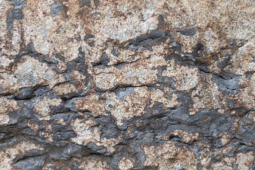 Old stone dark brown wall, textured background, close up