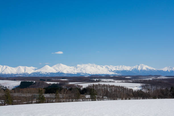 istock Upland field where snow remains and snowy mountains 1966087679