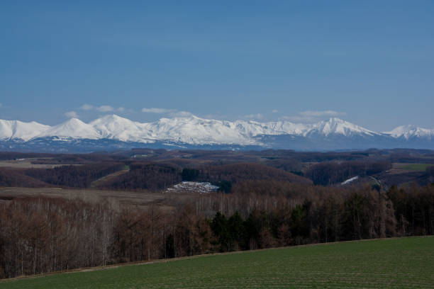 istock Spring hilly upland and snowy mountains with blue sky 1966088192