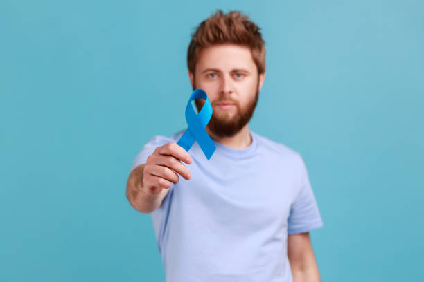 istock Man holding out blue awareness, disease symbol, looking at camera, support and care. 1966116695