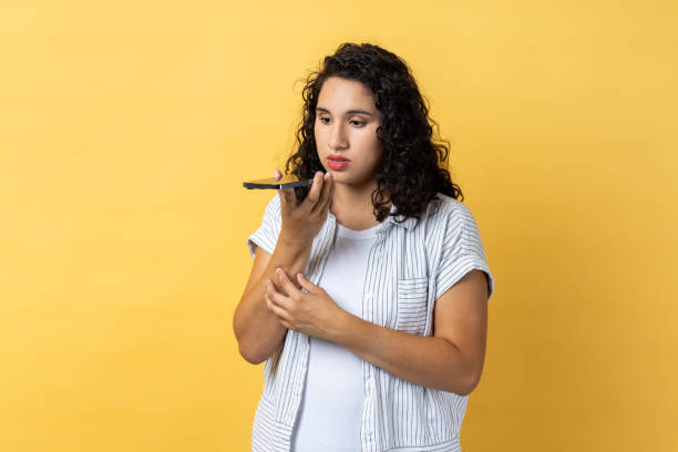 istock Woman talking to mobile phone, using voice assistant to record reminder, message. 1966119307