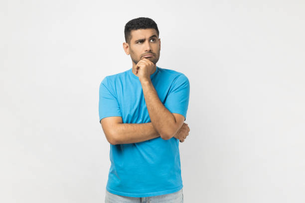 istock Pensive thoughtful man wearing holding his chin, looking away with puzzled expression. 1966119322