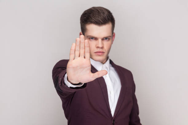 istock Man keeps palms towards camera says no with displeased expression and makes stop gesture. 1966124099