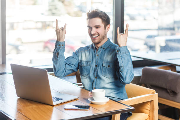 istock Crazy excited cool man freelancer working on laptop showing rock and roll gesture to computer screen 1966124646