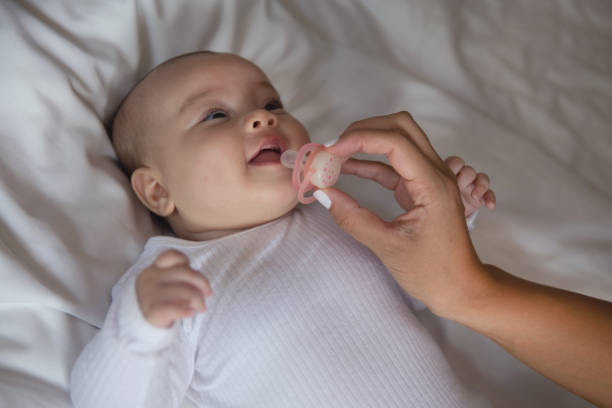 Close-up shot of Unrecognizable Mother Giving Her Baby Girl a Pacifier