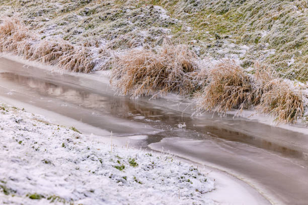 riacho congelado com gelo e neve na beira da água - ice floe - fotografias e filmes do acervo