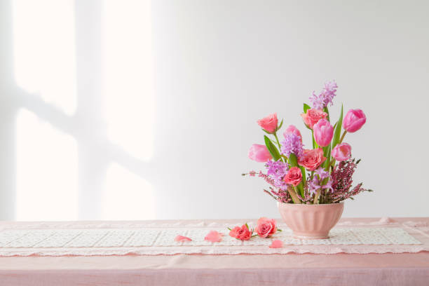 istock pink flowers in vase on background white wall 1966144576
