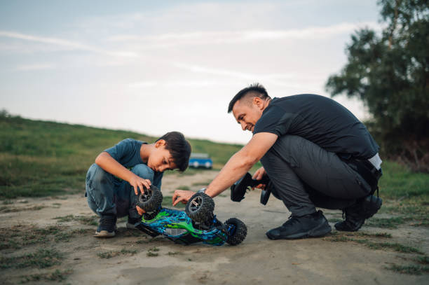 istock Happy dad and son looking at overturned toy car outdoors during playtime. 1966145132