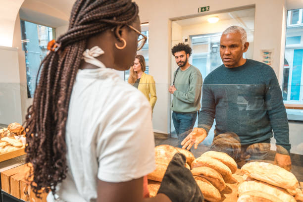 istock Black Female Offering Freshly Baked Bread At An Artisan Bakery 1966175737
