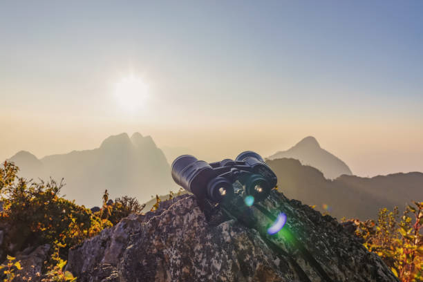istock binoculars on top of rock mountain at beautiful sunset background. 1966214982