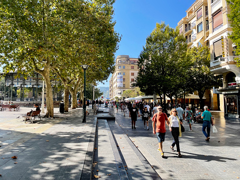 Pedestrians enjoying the sun on San Juan Kalea in San Sebastian, Spain. October 2023