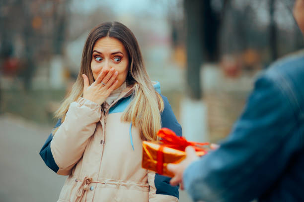 Surprised Girl Feeling Embarrassed for Not Buy a Present Forgetful girlfriend feeling shy and puzzled forgetting the anniversary unusual couple stock pictures, royalty-free photos & images