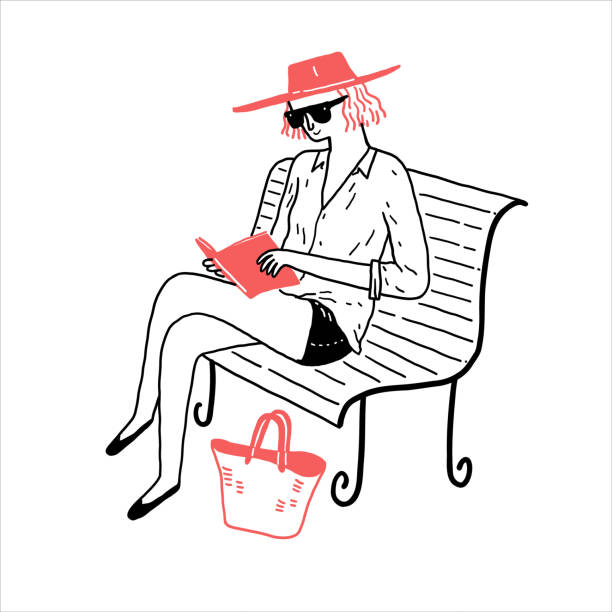 istock A young woman in casual clothes sits and reads a book on a park bench. 1966260375