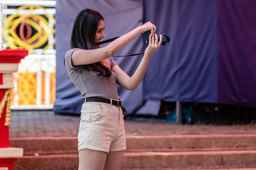 Chinese Tourist shooting photography with her friend in theme park