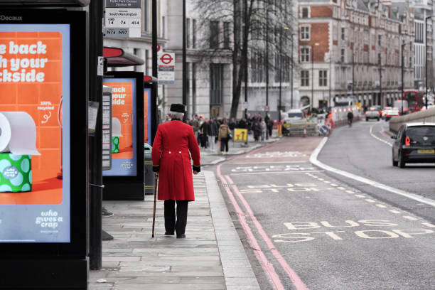 赤いジャケットを着た男、赤いチュニックコートを着た年金受給者が通りを歩く、ロンドンバス停、ハイドパークコーナー駅、ナイツブリッジストリート、ハイドパークコーナー、ロンドン� - london england park london hyde street ストックフォトと画像
