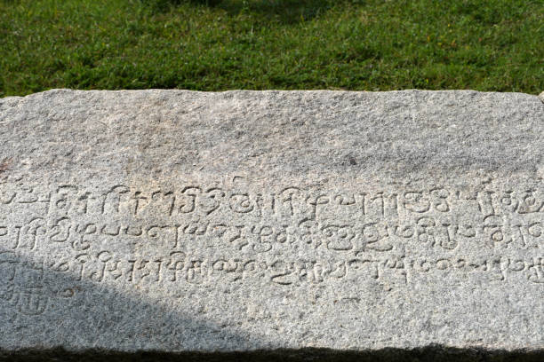istock Tamil Inscription in stone with green grass background. 1966307272
