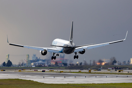 GATWICK AIRPORT, ENGLAND, UK – SEPTEMBER 13 2018: View directly down the runway as an easyJet Airlines plane takes off from Gatwick Airport with planes coming in to land behind it in the background.