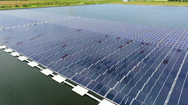 Floating solar photovoltaic panels at sustainable electrical power plant for generating clean electric energy. Concept of renewable electricity with zero emission on water surface
