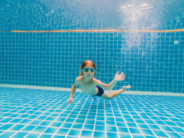 istock Underwater Young Boy Fun in the Swimming Pool with Goggles. Summer Vacation Fun 1966444665