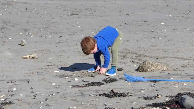 Red headed boy playing on a sandy beach in Northern Ireland Holidays in UK