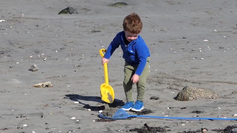 Red headed boy playing on a sandy beach in Northern Ireland Holidays in UK