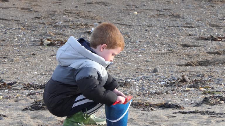 Red headed boy playing on a sandy beach in Northern Ireland Holidays in UK