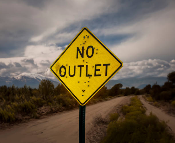 A road sign stating No Outlet riddled with bullet holes A road sign stating No Outlet riddled with bullet holes end gun violence stock pictures, royalty-free photos & images