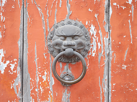 Istanbul, Turkey-December 13, 2015: Metal lion head doorknob of a wooden door on Beyoglu Istiklal Caddesi. There are carvings on the door.