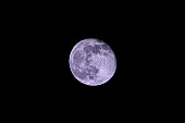 a waning full moon in the black night sky