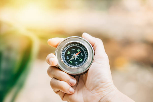 istock Hiker navigates the forest holding a compass to overcome confusion. The compass in the traveler hand signifies exploration and finding one path in the wilderness. 1966790771