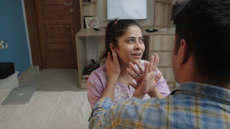 Hand of young wife touching depressed husband's cheek and consoling him at home