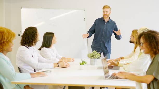 istock Man leading a meeting in a coworking using a board 1966814557