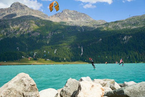 Engadin, Switzerland - July 16, 2023: Leisure time on the lake in the mountains. Water sports enthusiasts enjoying their passion. Sunny summer day. Lake Silvaplana, engadin, Sankt Moritz, swiss.