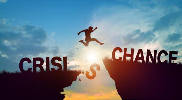 istock Silhouette man jumping form cliff with Crisis word to another cliff with Chance word. 1966863544