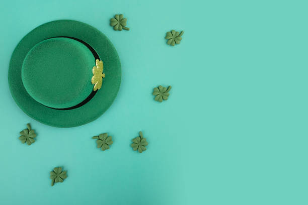 Saint patrick day concept. Leprechaun hat with green clover on green, shiny background