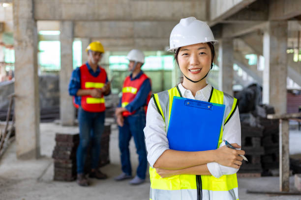 Team of asian engineer in full safety gear is inspecting inside the building structure for investigation over specification on construction site industry and quality control usage