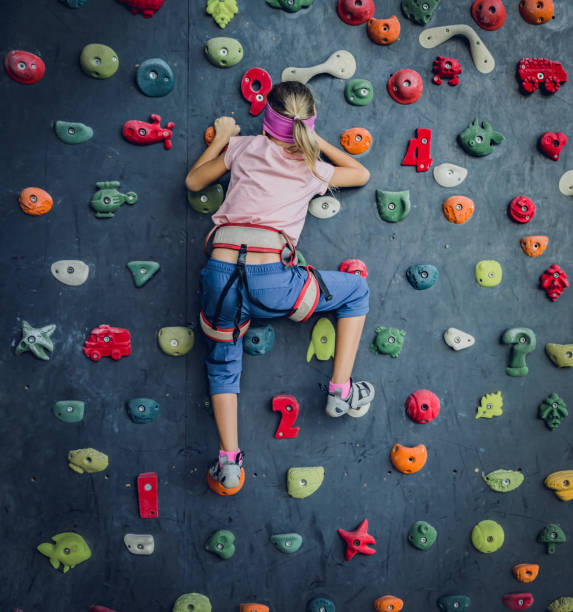 istock A strong baby climber climbs an artificial wall with colorful grips and ropes. 1966998654