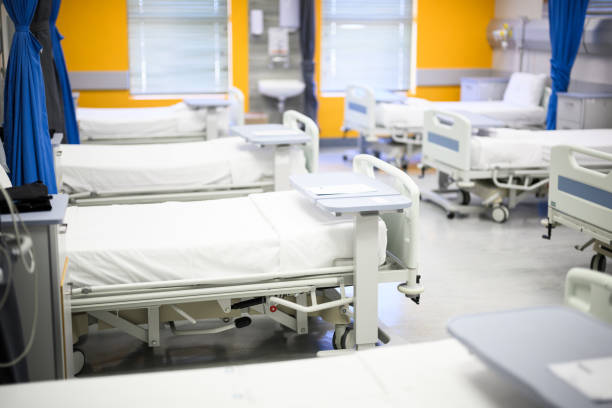 istock Neat and tidy hospital beds with curtains tide back in empty ward 1967004473