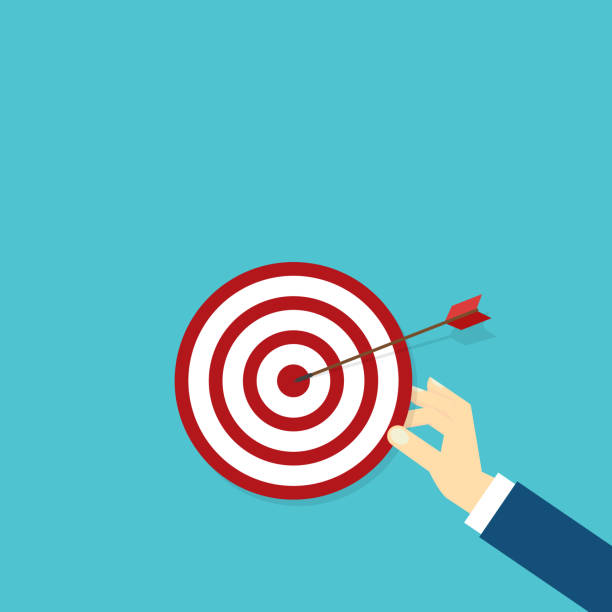 istock Hand holding a target, showing a goal. Red arrow hits the center. Business challenge failure and success concept. 1967015489