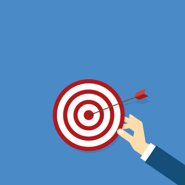 istock Hand holding a target, showing a goal. Red arrow hits the center. Business challenge failure and success concept. 1967016006