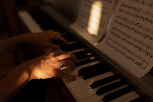 Close up photo of a woman hands playing the piano