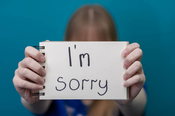 a woman holds a card with the words sorry in her hands The child holds a card with the words I'm sorry in his hands guilty stock pictures, royalty-free photos & images