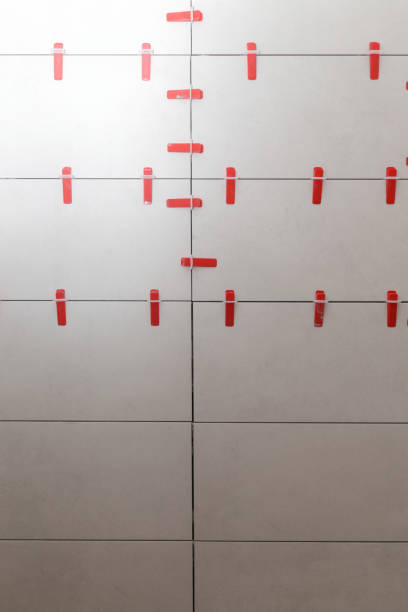 istock Flat wall plastic tile leveling system. Process of installation of tiles in the bathroom step by step. DIY home improvement. 1967055431