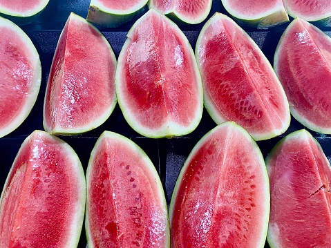 Horizontal of quarter cut fresh farm watermelons wrapped and ready to eat in fresh country farmers markets Australia