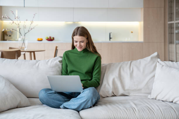 istock Woman freelancer working on laptop on knees, distance learning at home, watching webinar 1967060309