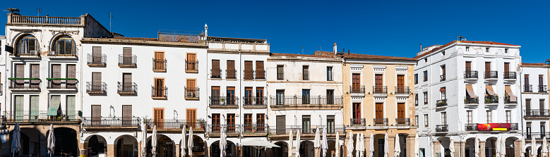 Facades of the old houses surrounding the Plaza Mayor in the city of Caceres, Spain