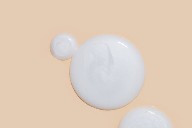 istock Cosmetic product smear white moisturizing lotion isolated on beige, squeezed out and smeared portion of skincare cream product testing. 1967093659