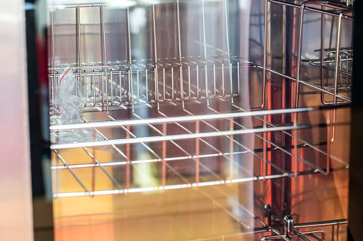 Empty dishwasher with metal rack and container